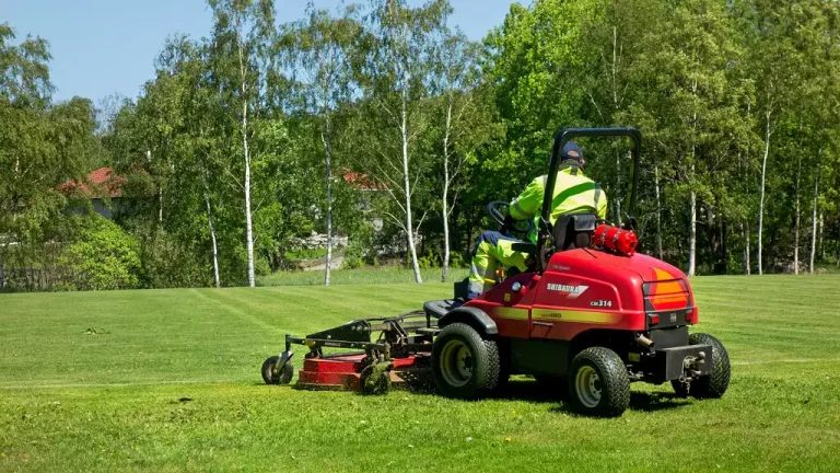 Åkgräsklippare som klipper en gräsmatta
